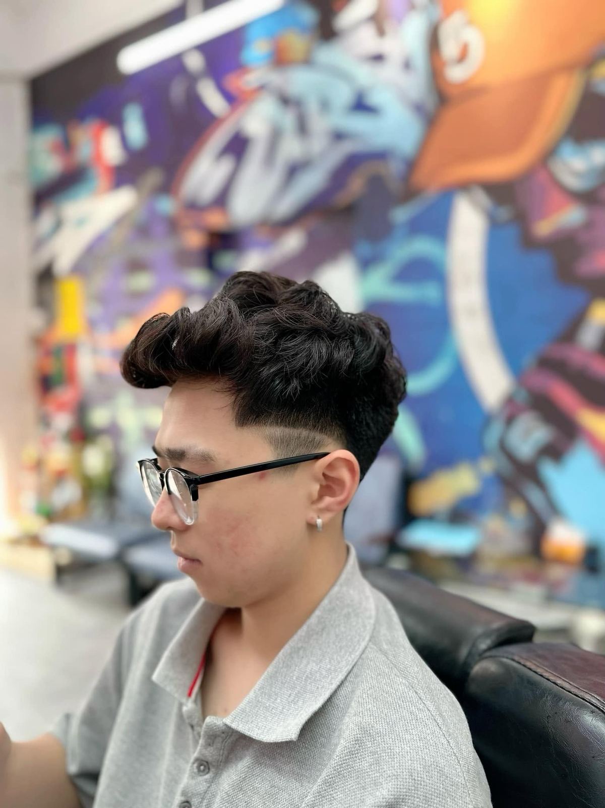 Kiểu tóc xoăn phồng undercut, đeo kính