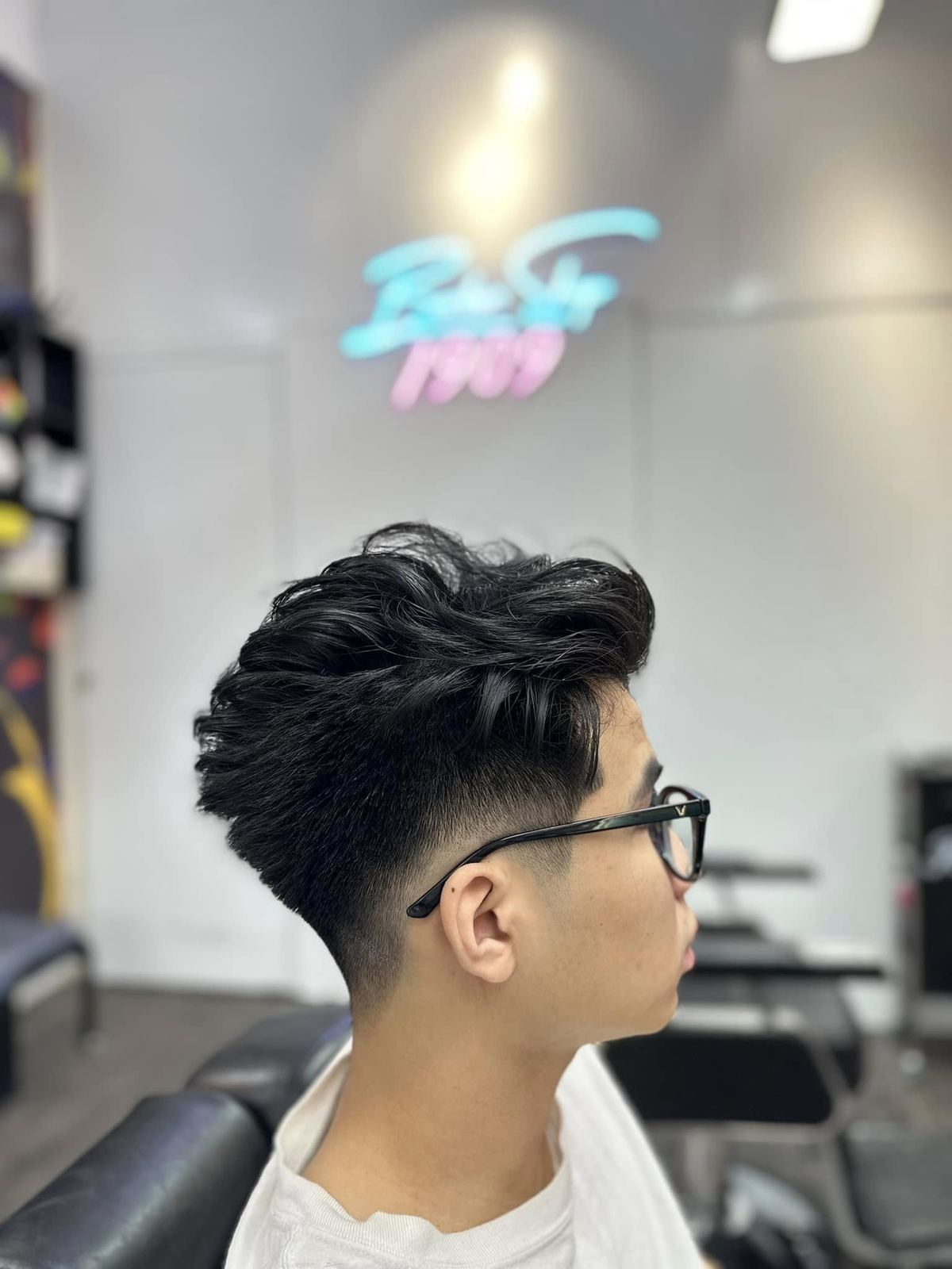 Kiểu tóc quiff phồng đen, đeo kính